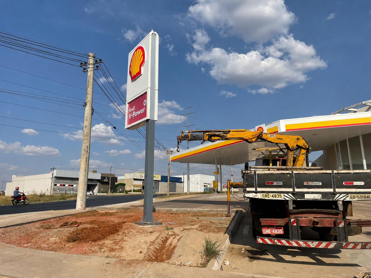 Caminhão munck da VIPPASI em obra de posto Shell, com o totem de preços instalado e a cobertura da pista ao fundo